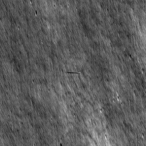 grayscale view of lunar surface with a smeared streak in the center of the image